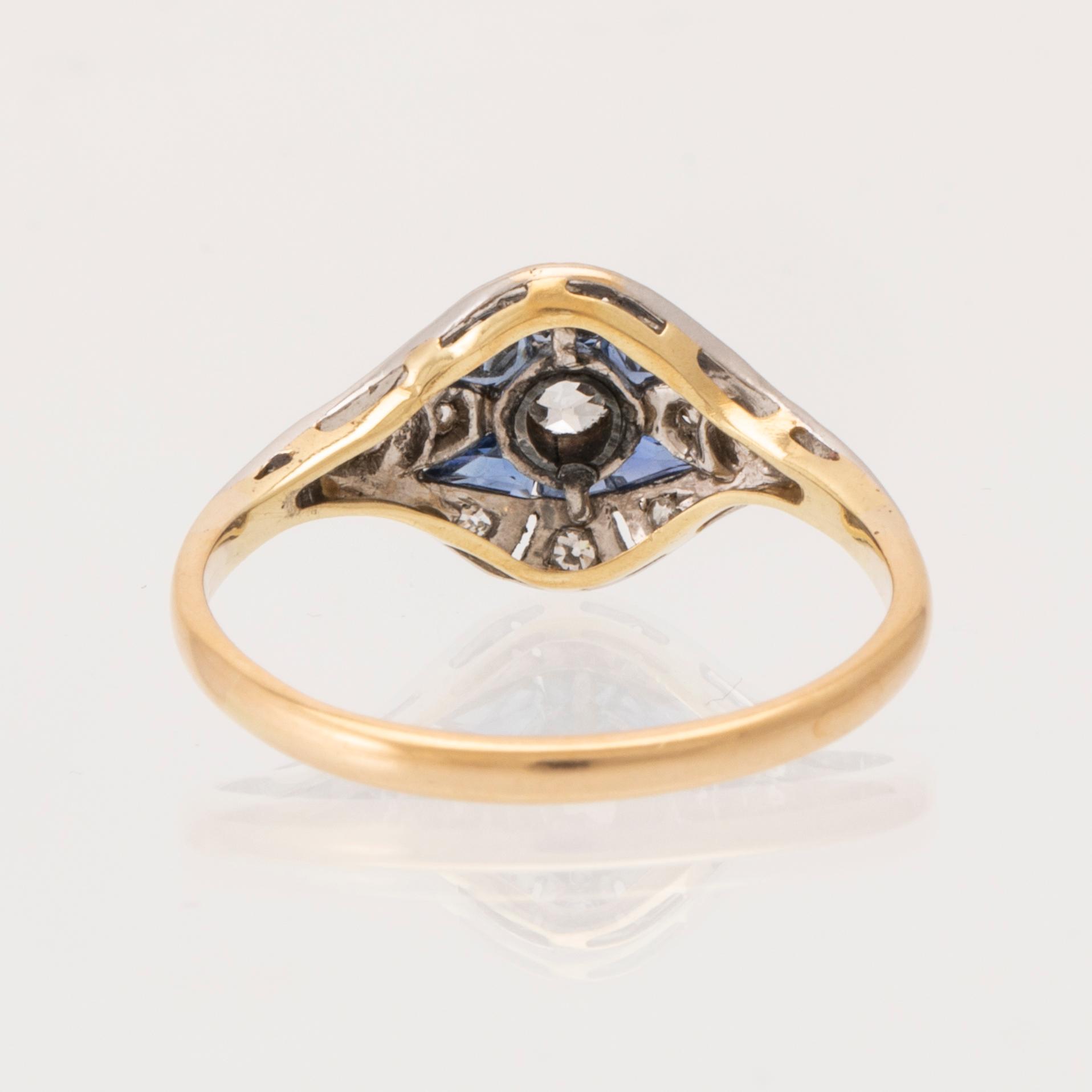 An 18K white and red gold ring set with old-cut diamonds and step-cut blue gemstones, Petterssons Stockholm 1937.