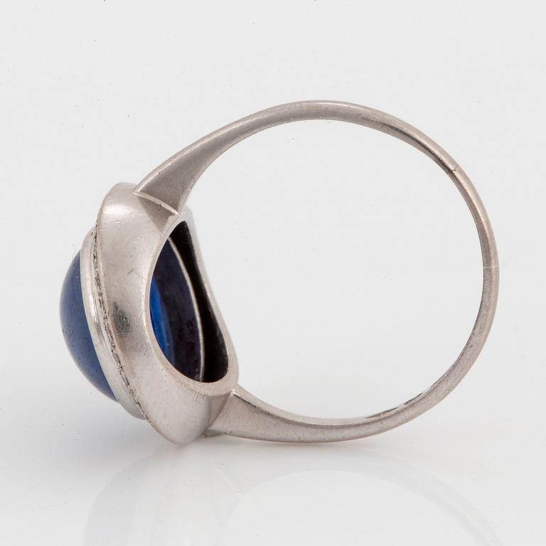 An A Tillander ring in 18K white gold set with a cabochon-cut sapphire and eight-cut diamonds.