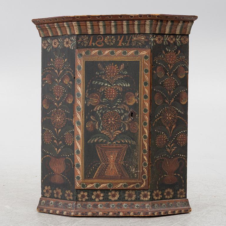 A corner hanging cabinet, dated 1844.