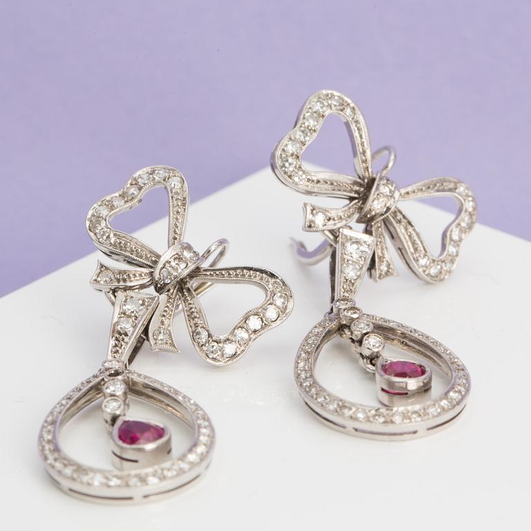 A pair of ruby and single-cut diamond earrings in the shape of bows. .
