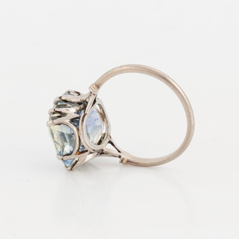 A ring set with a light blue, cushion-cut sapphire.