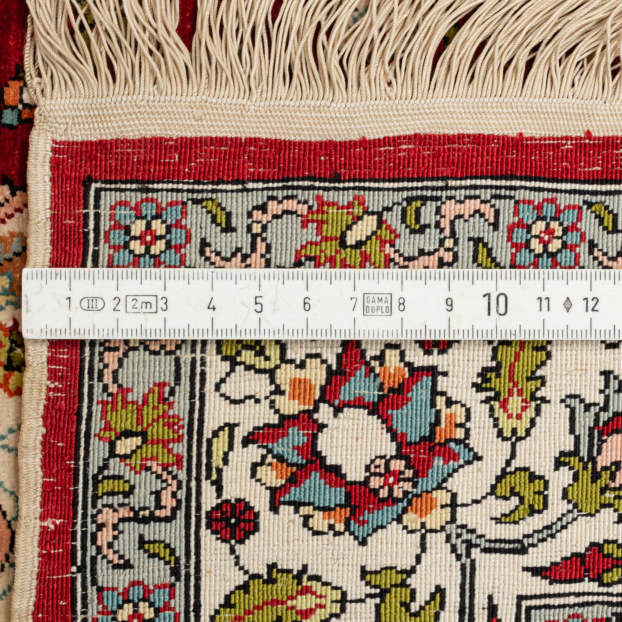 A silk Hereke rug, circa 91 x 63 cm.