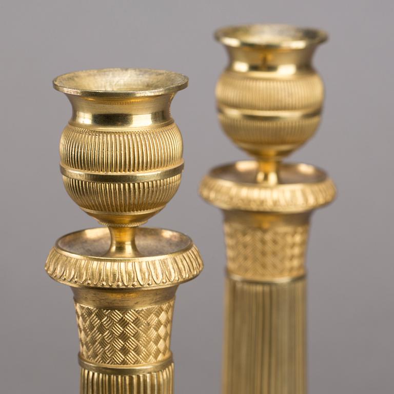 A pair of gilded bronze empire candlesticks, first half of the 19th century.