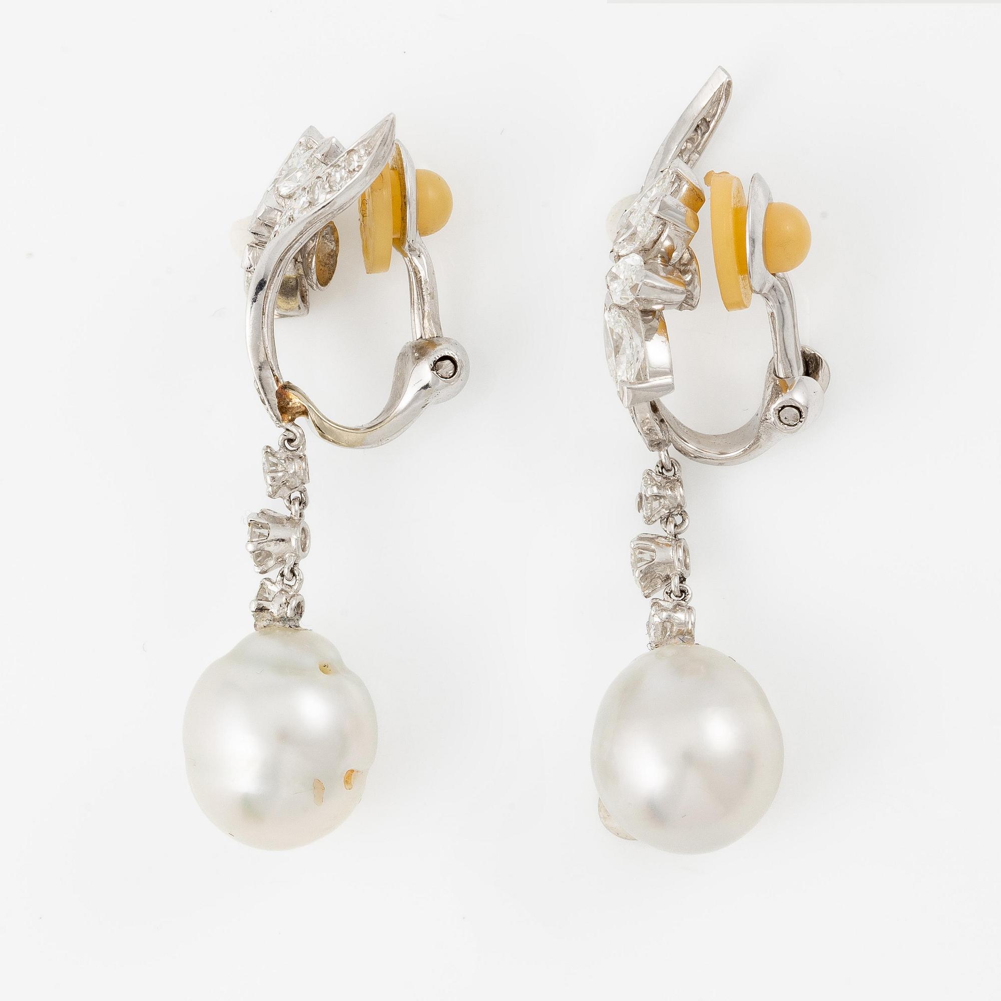 A pair of platinum earrings with cultured pearls and navette- and round brilliant-cut diamonds.