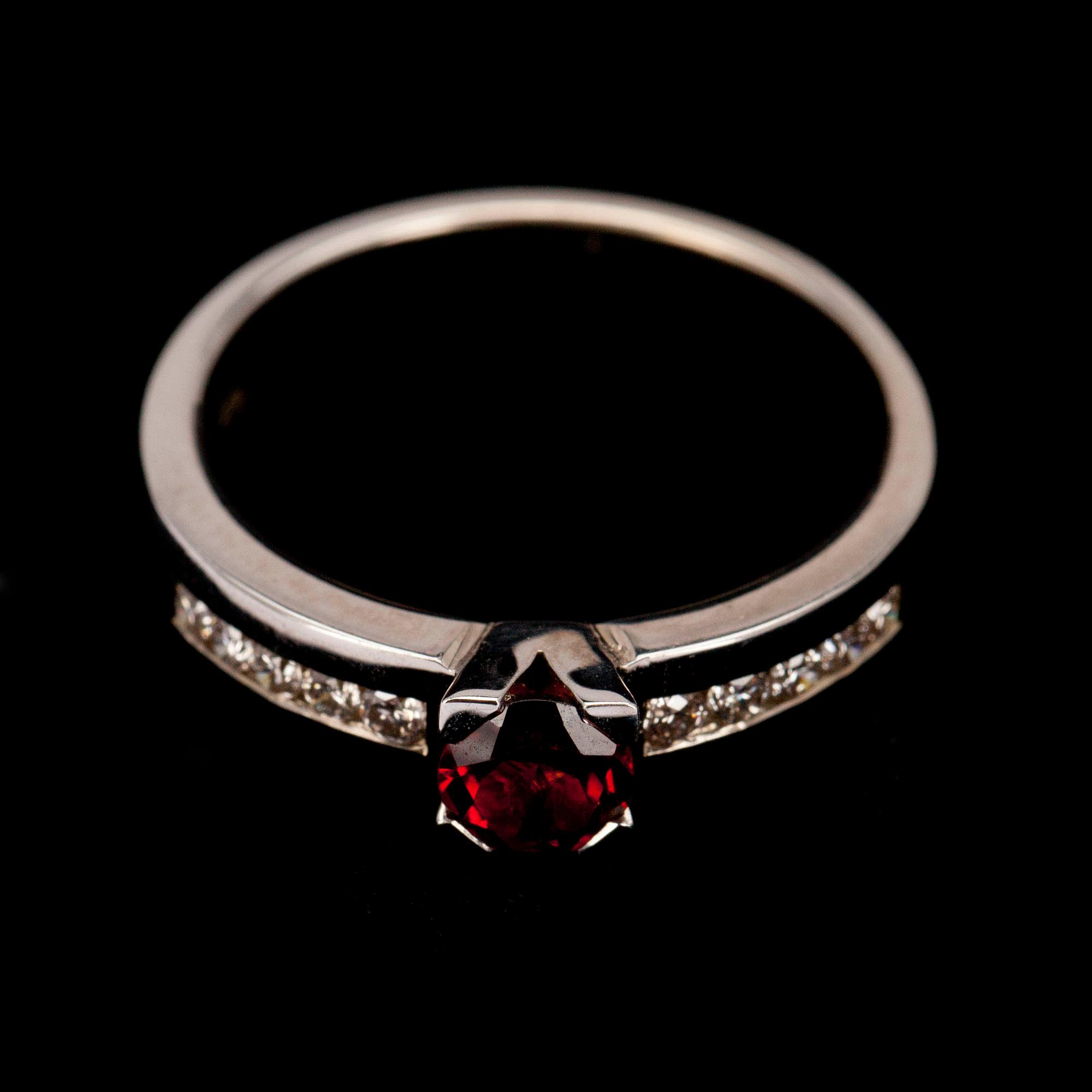 RING, vitguld 14K, fasettslipad granat 0,49 ct, briljantslipade diamanter diamanter tot. 0,21 ct. Vikt 4,7 g.