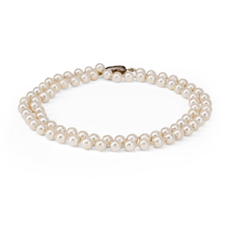 CÉLINE, a decorative white pearl necklace.