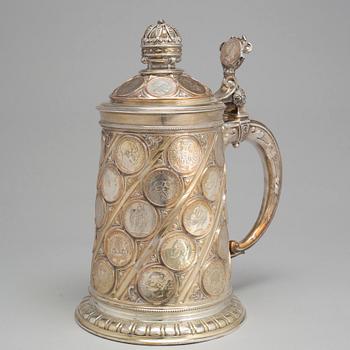 A late 19th century EPNS tankard with silver coins.