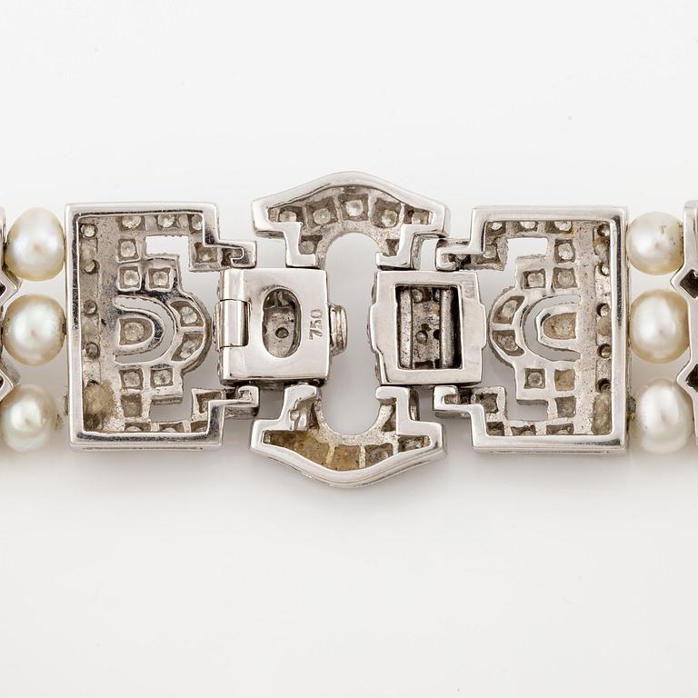 An 18K white gold bracelet set with cultured pearls and round brilliant-cut diamonds.