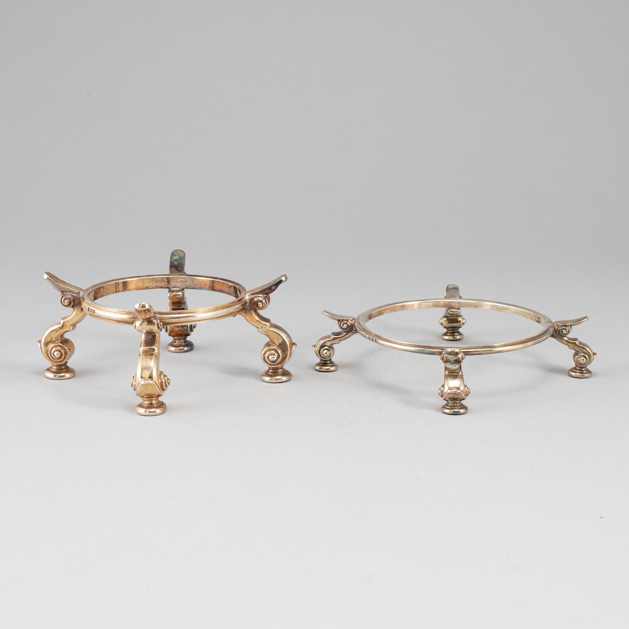 Two English silver heat-stands and dishes, marked LAC, London 1920 and 1923.