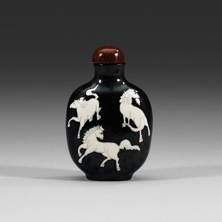 An enamelled porcelain snuff bottle with stopper, Qing dynasty (1644-1912).