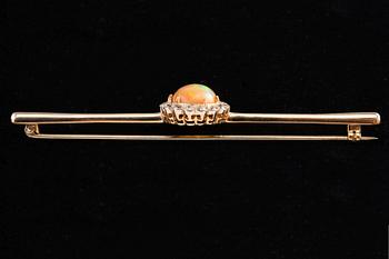 BROSCH, Briljantslipade diamanter ca 0.65 ct, Opal 10 mm.
14K guld. Ostämplad. Längd 85 mm, vikt 8,2 g.