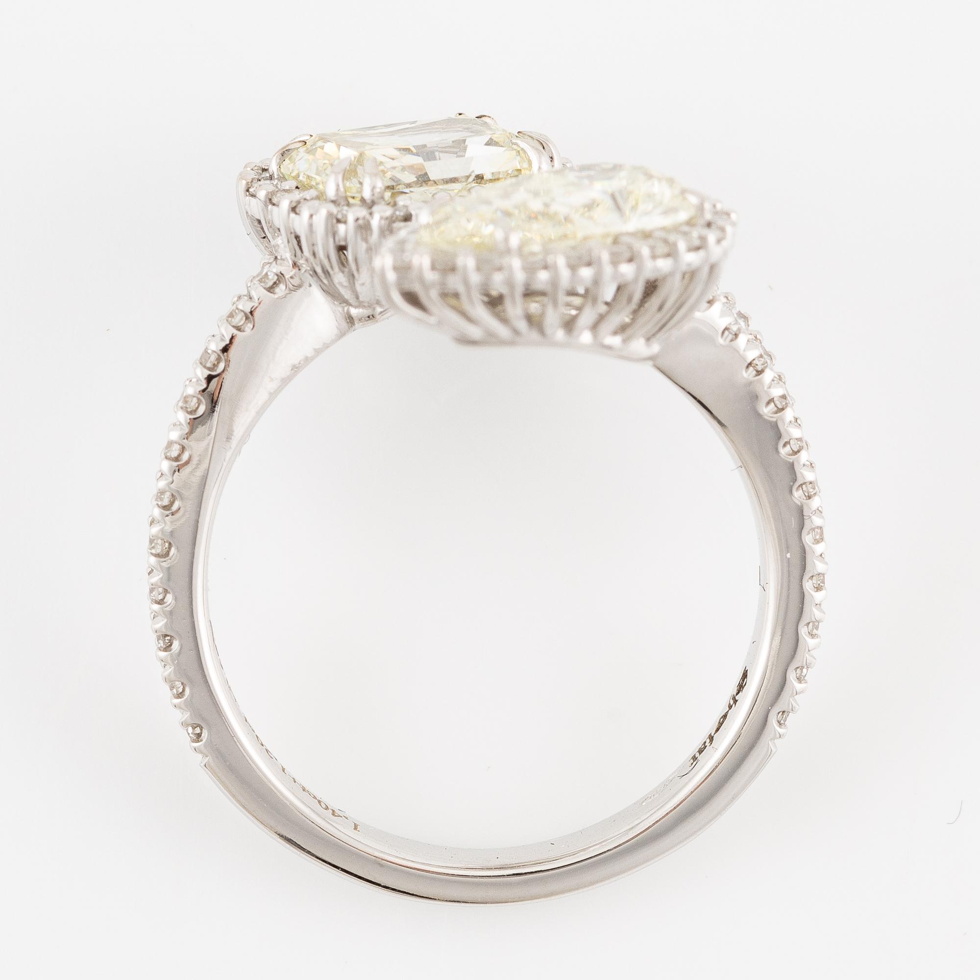 Crossover ring, 18K white gold set with pear-shaped and emerald-cut diamonds. Accompanied by GIA report.