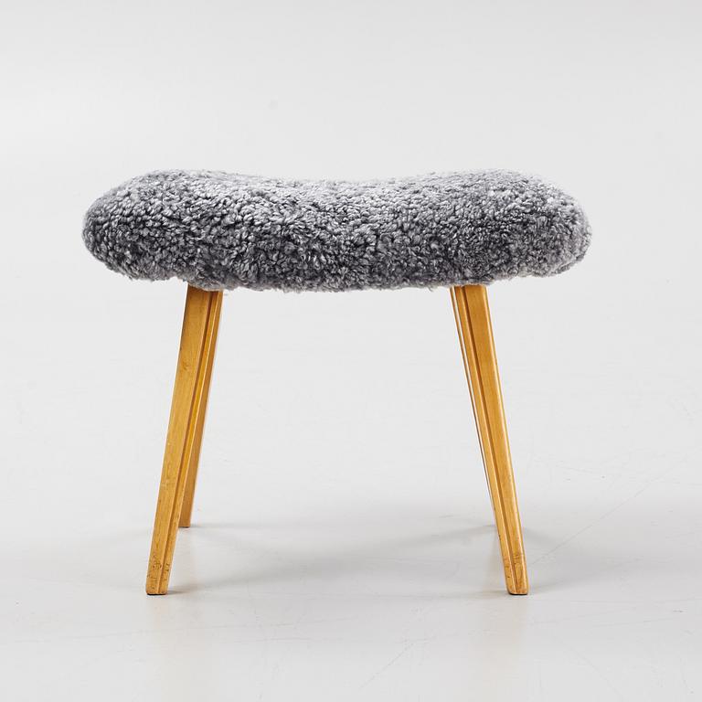 A birch stool with new sheepskin upholstery.