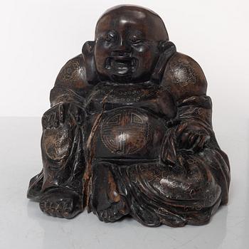 A Chinese wooden figure of Budai with silver inlays, Qing dynasty (1644-1912).