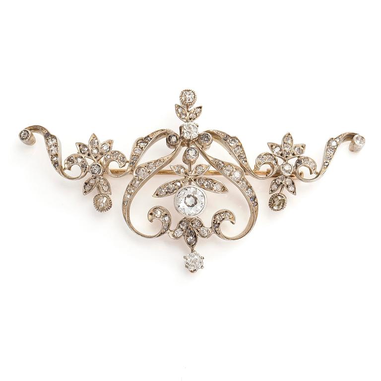 A 14K gold and silver brooch, with an old European brilliant, old mine- and rose cut diamonds.