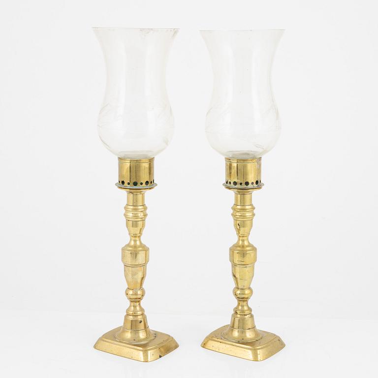 A pair of brass candlesticks with storm glass, 19th century.