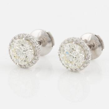 A pair of 18K gold earrings with round brilliant-cut diamonds.