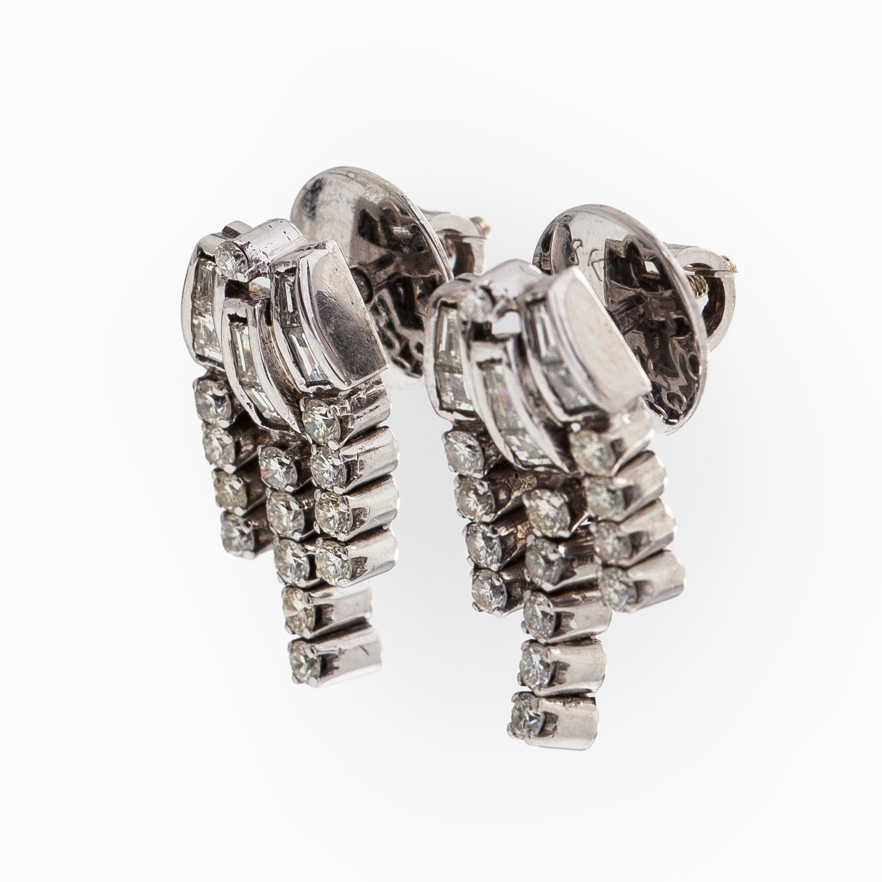 A pair of 18K white gold earrings set with baguette-cut and brilliant-cut diamonds.