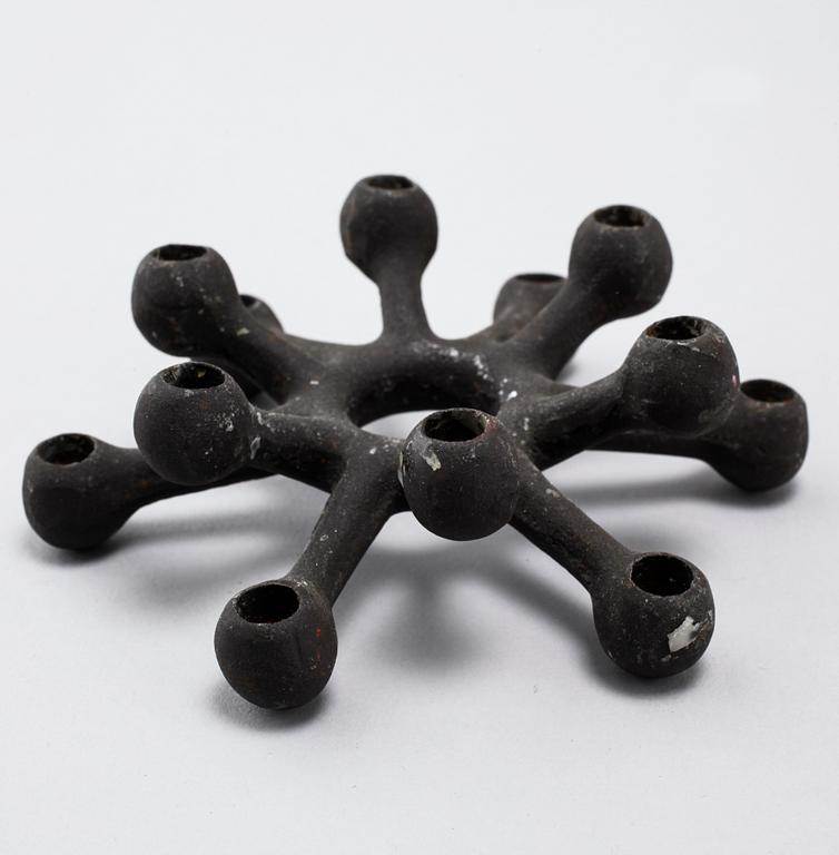 Four 1960s iron cast candle holders, designed by Jens Quistgaard for Dansk Designs .