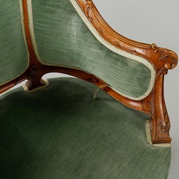 A rococo style sofa, two lounge chairs and a table, around the year 1900 and first half of the 20th century.