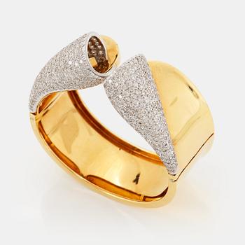 An 18K gold bangle set with round brilliant-cut diamonds.