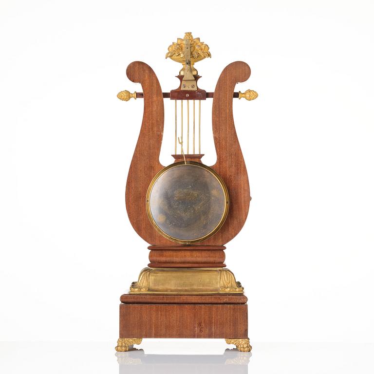 A French Empire mahogany, ormolu and gilt metal lyre-shaped mantel clock, early 19th century.