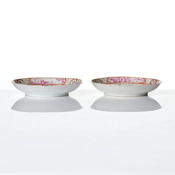 A pair of famille rose 'figural' tea cups with saucers, Qing dynasty, Qianlong (1736-95).
