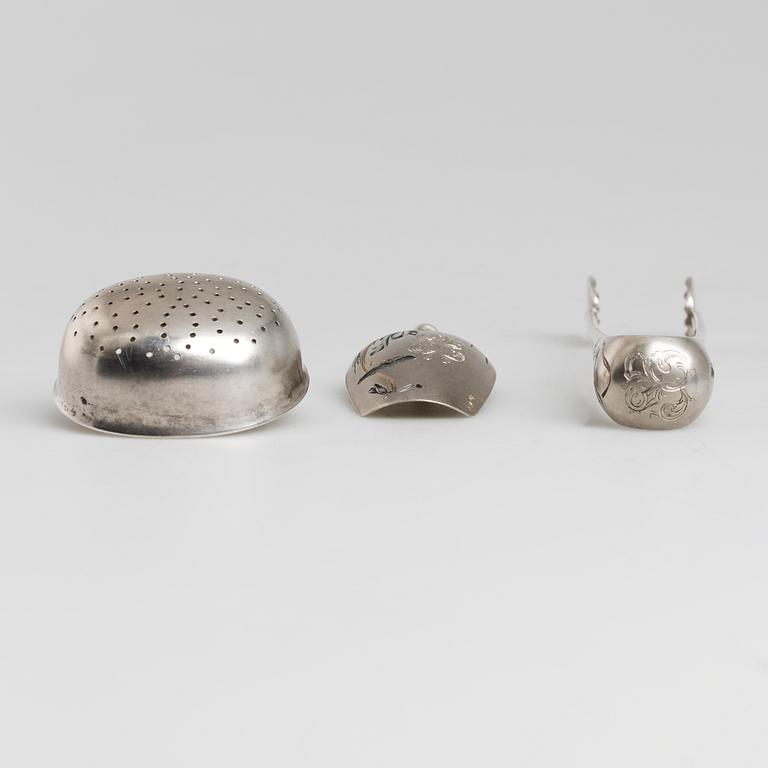 A Russian parcel-gilt tea caddy spoon, sugar thongs and sugar sifter, maker's mark Grigory Spitnev, Moscow, 1898-1914.