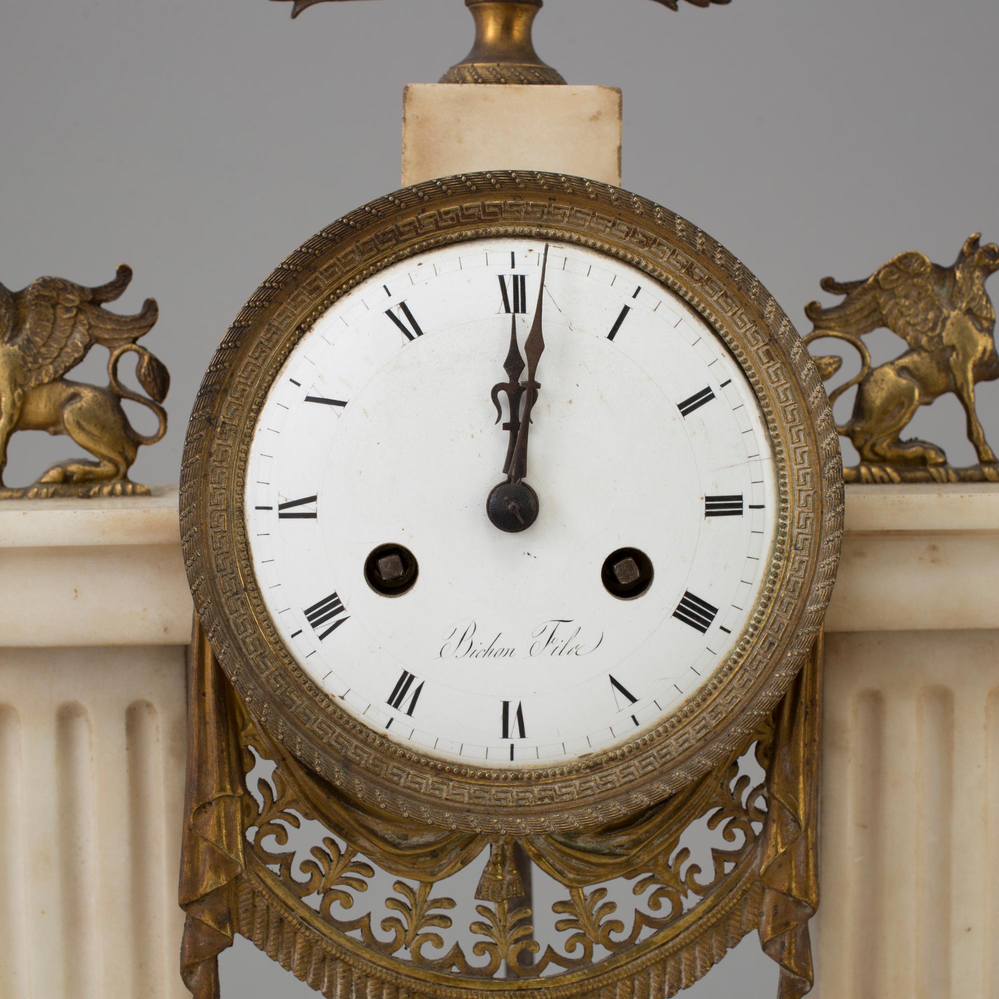 A FRENCH EMPIRE MARBLE AND BRASS MANTEL CLOCK, first half of the 19th century.