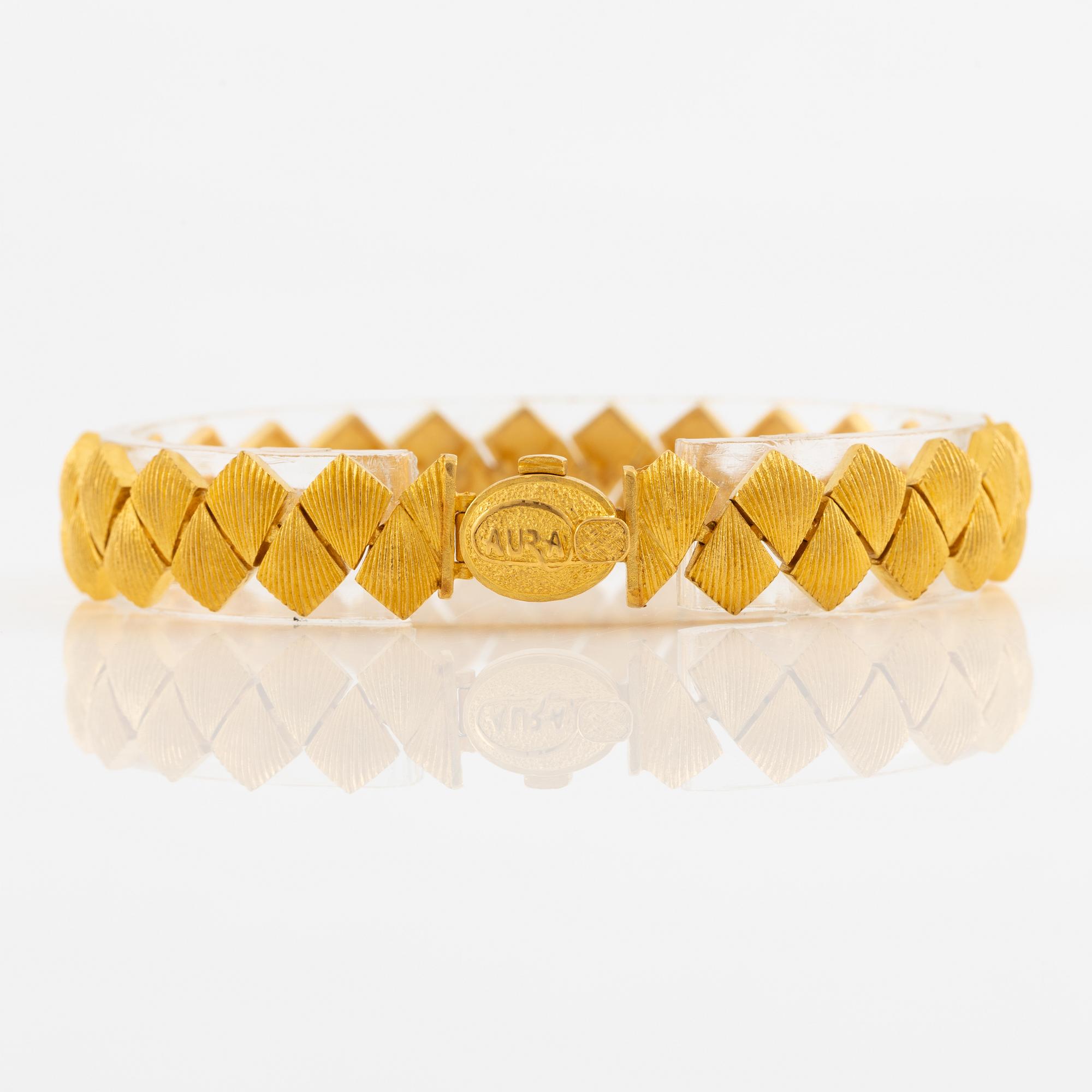 Garnityr av guldsmycken, en collier (14K), ett armband (18K), ett par örhängen (14K) och en ring (14K).