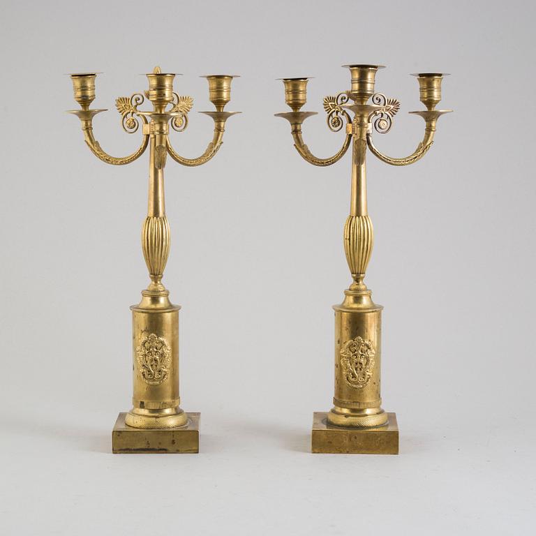 A pair of early 19th century brass candelabra for three candles.