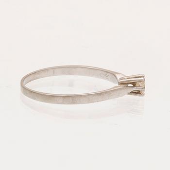 An 18K white gold ring with a round brilliant cut diamond.