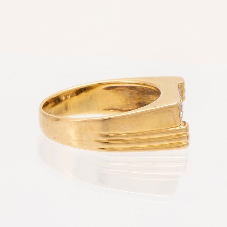 An 18K gold ring set with round brilliant cut diamonds.