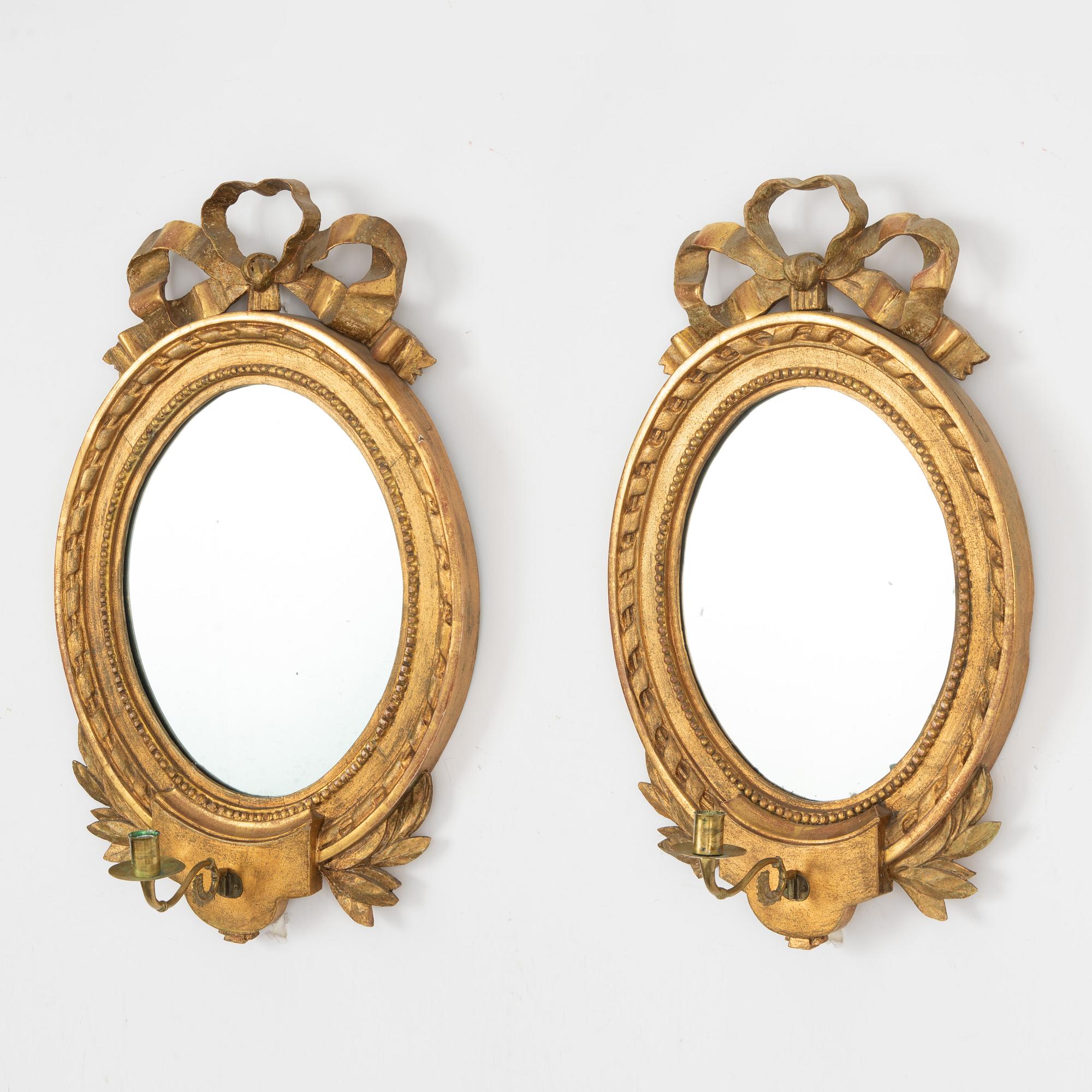A Gustavian one-branch giltwood girandole mirror (with an associated copy), Stockholm, late 18th century.