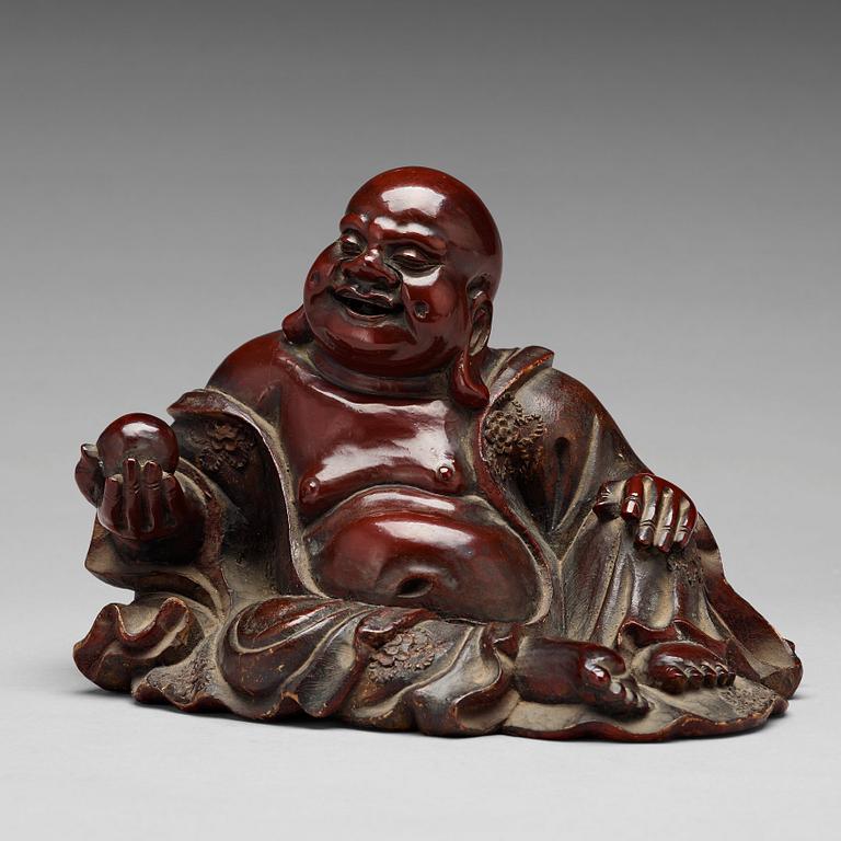 A seated wooden figure of Buddai, Qing dynasty, circa 1900.