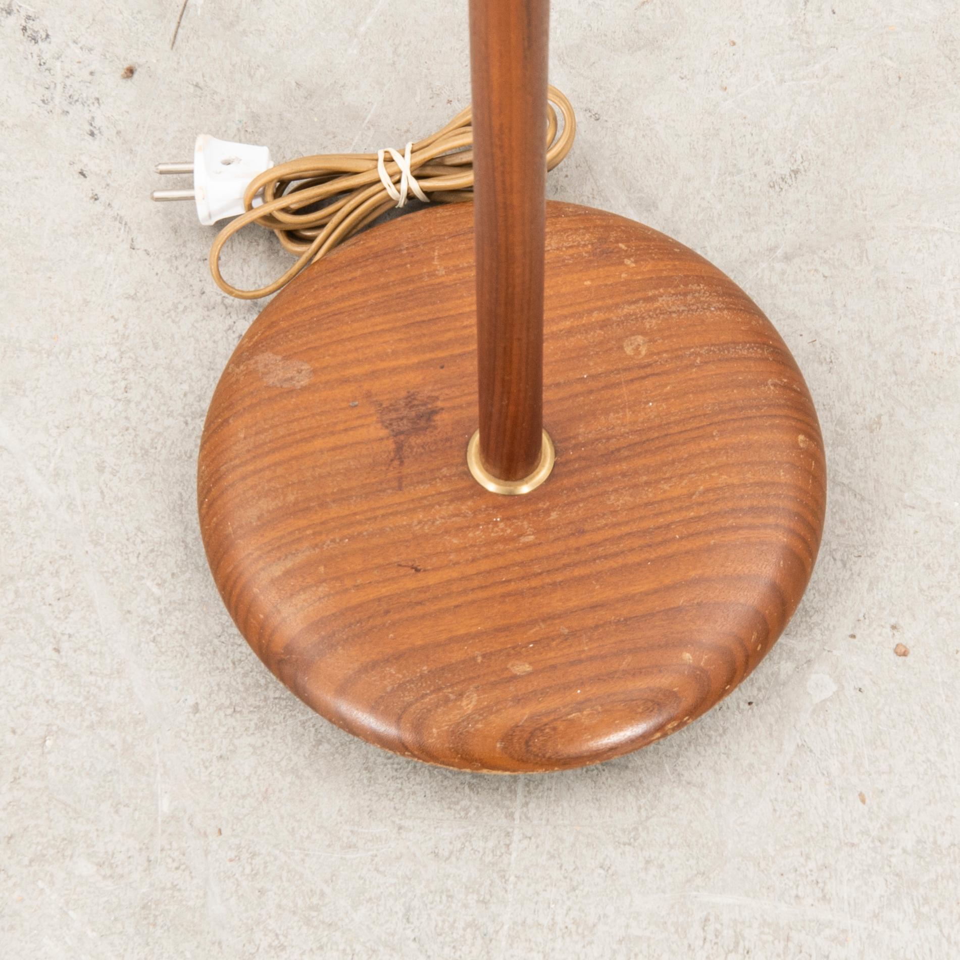 A teak and brass floor lamp from the first half of the 20th century.