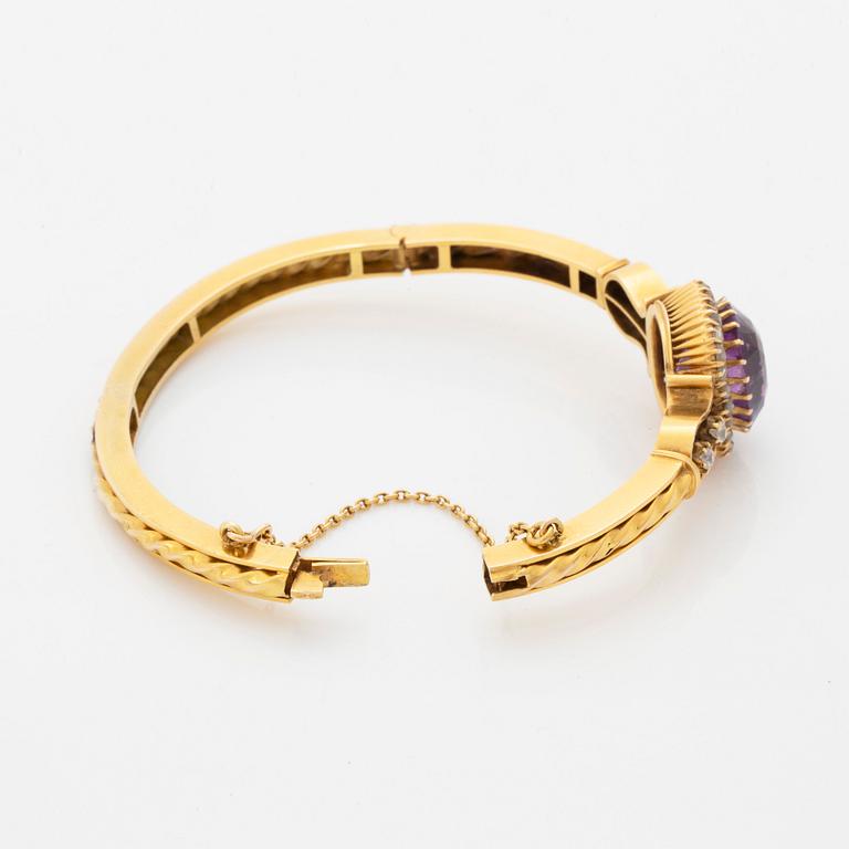 A 14K gold bangle set with a faceted amethyst and rose-and old-cut diamonds.