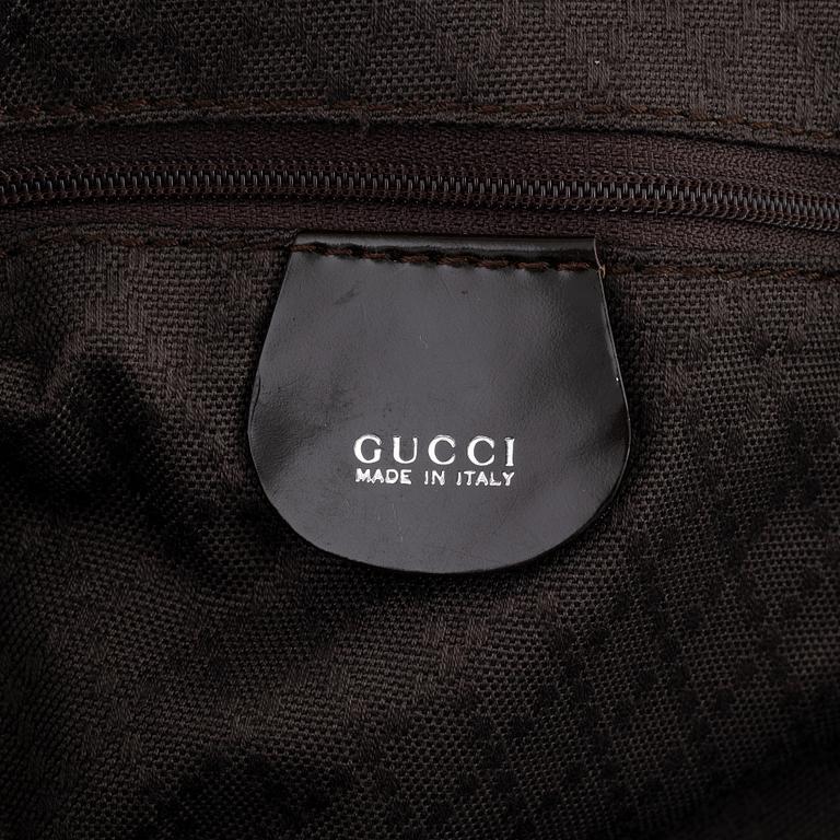 Gucci, a chocolate brown nylon handbag.
