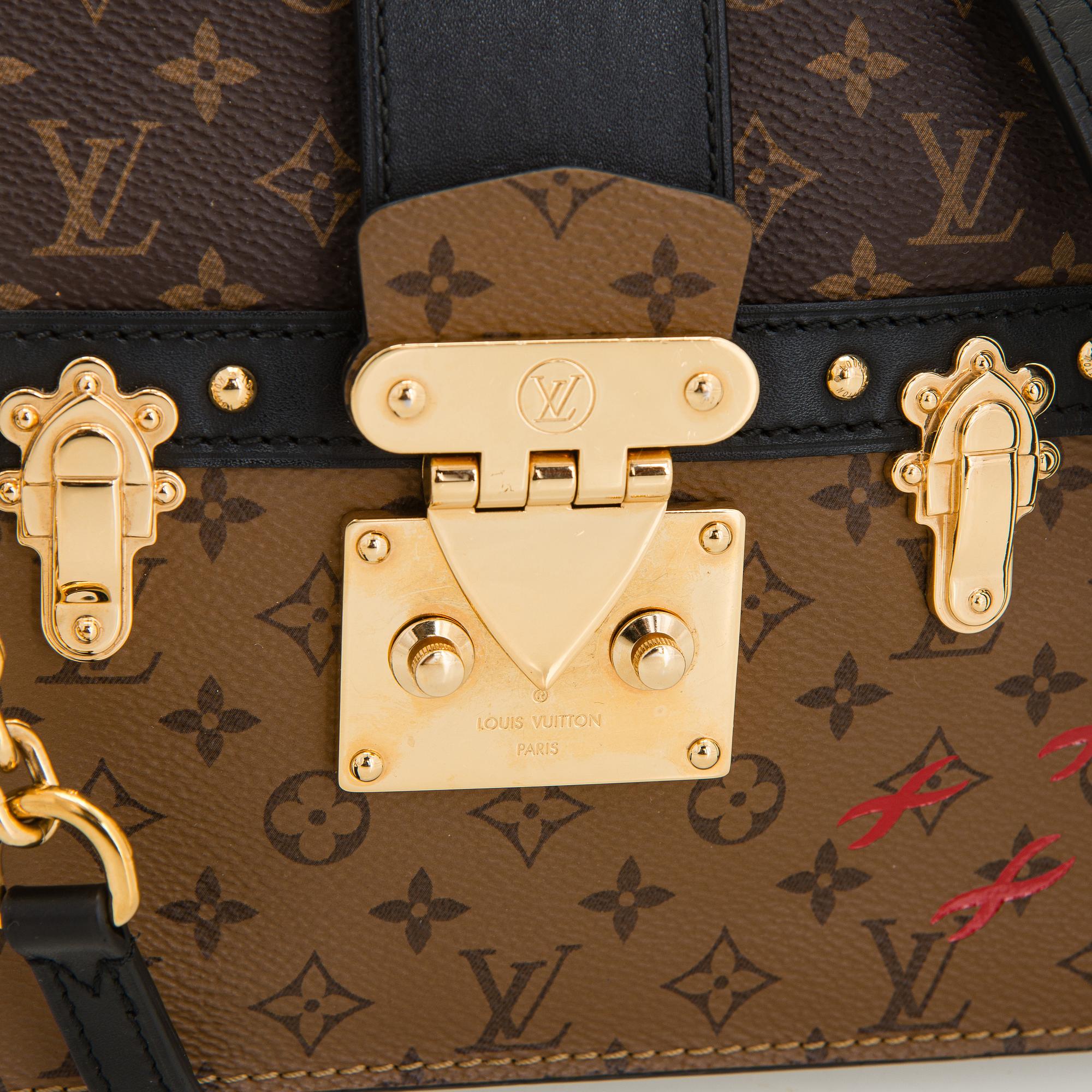 Louis Vuitton, a "Reverse Monogram Trunk Clutch" bag.