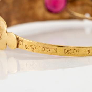 A pair of earrings in 18K gold with red glass, 9th century.