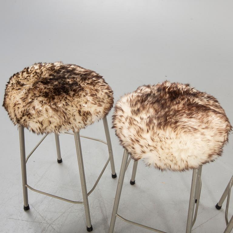 A set of four modern stolls with sheepskin.