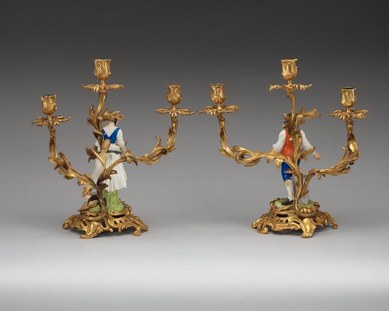 A pair of bronze candelabra with porcelain figures, French/English, second half of 19th Century.