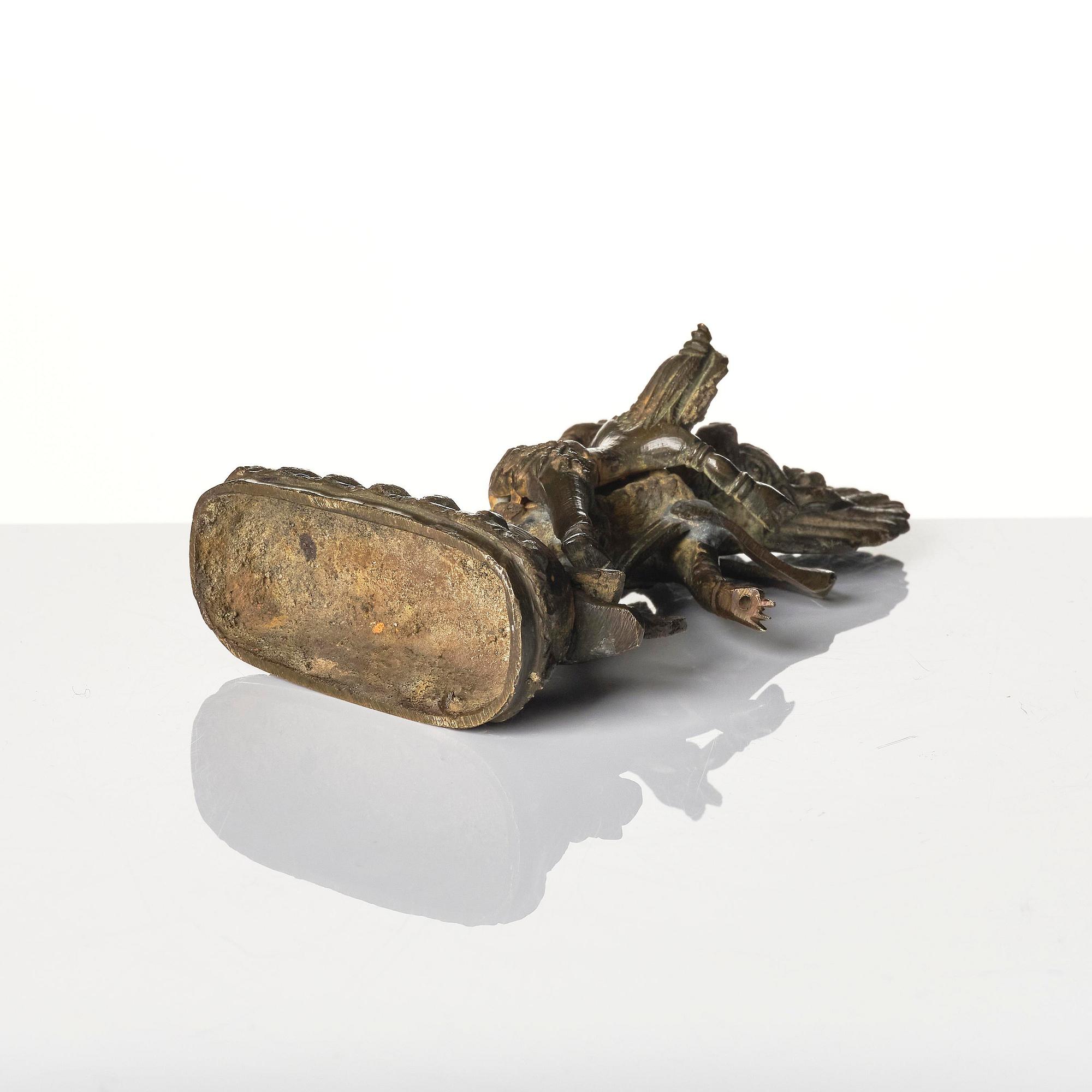 A bronze deity and a brass sacrificial bowl, Tibet, circa 1900.