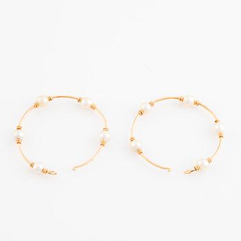 Gold and pearl hoop earrings.