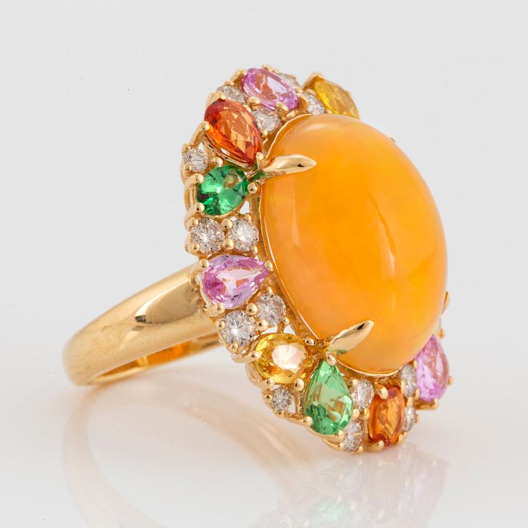 An 18K gold ring set with an opal, round brilliant-cut diamonds.