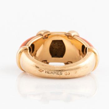 An 18K gold and coral Hermès ring.