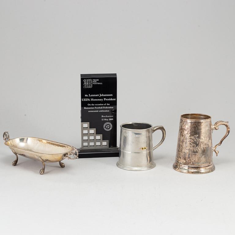 A WHITE METAL SCULPTURE, A CUP AND A BOWL.