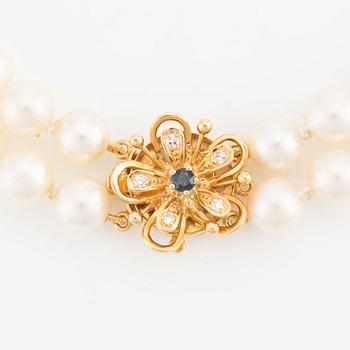 Necklace, double strand of cultured pearls, clasp in 18K gold set with eight-cut diamonds and a sapphire.