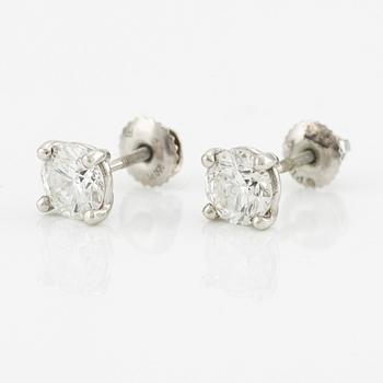 A pair of platinum earrings with round brilliant-cut diamonds.