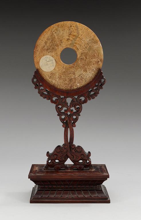 A jade Archaistic Bi disc with a wooden stand, Qing dynasty (1644-1912).